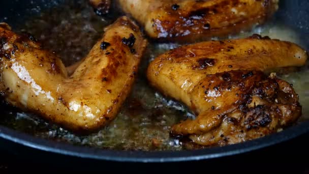 Alitas de pollo en escabeche en especias fritas en sartén hasta que estén doradas en aceite vegetal hirviendo. Sabrosa cocina doméstica o comida callejera. Primer plano. — Vídeos de Stock