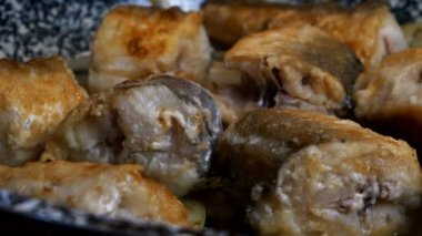 Kızartma tavasında parçalanmış beyaz deniz balığı yahnisi pişirmek. Pişmiş hake veya altın kabuklu pollock..