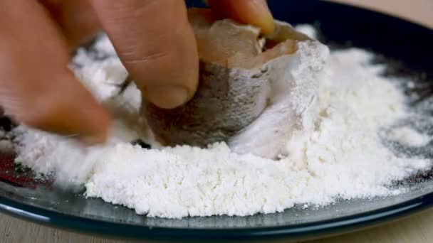Chef sumerge rebanadas de merluza o pescado pollock en harina en el plato para la preparación de delicioso plato de pescado. Receta de pescado frito. Enfoque selectivo. — Vídeo de stock
