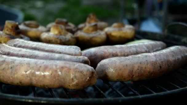 Friggere le salsicce bavaresi grasse cotte alla griglia o alla griglia. Con i funghi. Primo piano. — Video Stock