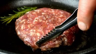 Kıymalı hamburgerler için ızgara biftek ya da domuz pirzolası pişirmek. Kızartma tavasında kızgın yağ üzerinde. Mutfakta kızartılmış et. Yakın plan..