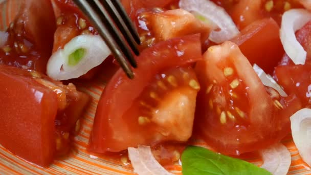 Ест свежий витаминный салат, вилку взять кусочек помидора и лука на коричневой тарелке. Здоровое вегетарианское или веганское питание. Средиземноморская диета. Выборочный фокус. Крупный план. — стоковое видео