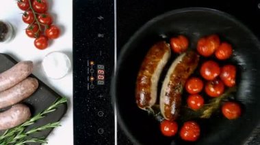 Domatesli yağlı beyaz bavyera sosisi ve elektrikli fırının üstünde kızartma tavasında kızartılmış biberiye. İngiliz ya da Alman, Avrupa ya da Amerikan kahvaltısı. Üst Manzara. Yukarıdan aşağıya yemek. Yakın plan..