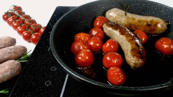 Las salchichas bavarianas blancas grasosas con tomate y ramita de romero se fríen en una sartén en una estufa eléctrica. Desayuno inglés o alemán, europeo o americano. Primer plano. — Vídeos de Stock