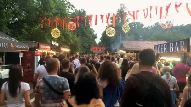 Kiev, Ucraina, luglio 2021: - Un sacco di persone e pedoni varietà, attivo a piedi sulla strada affollata sul marciapiede. Vita di strada nel centro della città. Vista ad angolo basso. Vista posteriore. Primo piano. — Video Stock