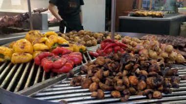 Kiev, Ukrayna, Temmuz 2021: - Kuzu ya da domuz pirzolası, patates, mantar, dolma biber, sokak pazarında büyük döner ızgara. Sokak yemekleri festivali. Yakın plan..