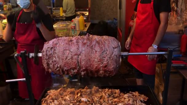키예프, 우크라이나, 2021 년 7 월: 도너 케밥 (Doner kebab) 또는 샤와르마 (shawarma) 는 길거리 음식 시장에서 수평으로 걷는 사람을 위해 준비 된다. 터키인이나 아랍 패스트 푸드. 맛있고 만족 스러운 간식이야,자 이 로스. 클로즈업. — 비디오