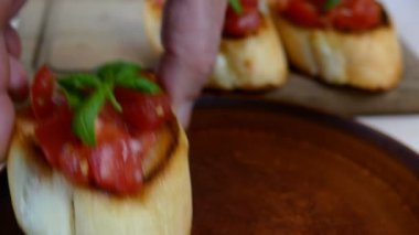 Klasik İtalyan ya da Akdeniz bruschetta 'sı kızarmış baget ve üzerine domates serpiştirilmiş. Fesleğen yapraklarıyla süslenmiş. Sağlıklı vejetaryen ve vejetaryen atıştırmalıkları. Yakın plan..