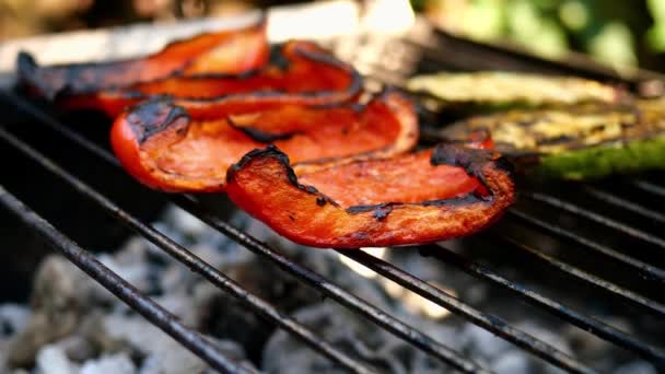 Chutná zelenina červené papriky připravené na grilu nebo otevřené grilování, jsou flip je s vařením tong během smažení. Horké chutné vegetariánské nebo veganské zdravé jídlo. Detailní záběr. — Stock video