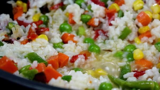 Het roosteren van traditionele Mexicaanse groenten meng maïs, rode paprika, groene bonen, groene erwten, wortel en rijst in koekenpan. Lekker vegetarisch of veganistisch recept. Huishoudelijke keuken. — Stockvideo