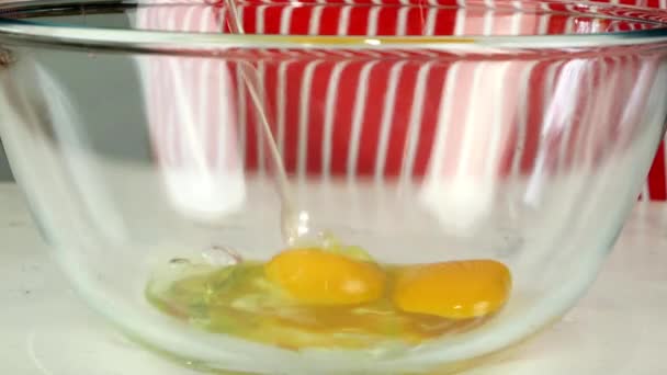 Vařit nalije tři kuřecí vejce v průhledné míse a bičuje je šlehačkou nebo drátem. Vyrábíme pečivo, omeletu nebo majonézu ve vaší kuchyni. Detailní záběr. — Stock video