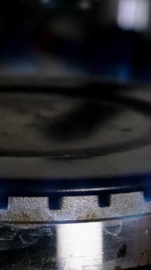 Gaz metan gazı ya da propan gazı sobasının yanma ve ortaya çıkma süreci. Mutfak ocağı kapanıyor. Doğal gaz iltihabı. Seçici odaklanma. Dikey format. Yakın plan..