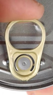 El, metalik teneke konserve ve terbiye edilmiş mısır açar. Metal kapağı kaldırıyor. Sağlıklı vejetaryen ya da vejetaryen konserveleri. Üst Manzara. Dikey video. Yakın plan..