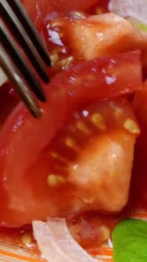 Taze vitamin salatası, çatal, domates ve soğanı al ve kahverengi tabağa koy. Sağlıklı vejetaryen ya da vejetaryen yemekleri. Akdeniz diyeti yemekleri. Seçici odaklanma. Dikey video.