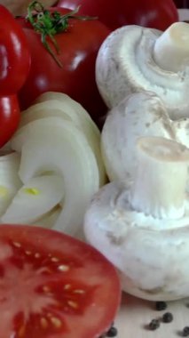 Şef yemek hazırlamak için ahşap doğrama tahtasına büyük keskin bir bıçakla mantar kesiyor. Sağlıklı beslenme konsepti. Yemek pişirme süreci. Dikey video.