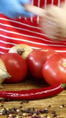 Şef, kesme tahtasında pişirmeden önce domuz etini mutfak çekiciyle yener. Domuz pirzolası hazırlamak için. Üzerine baharat serp. Dikey video.