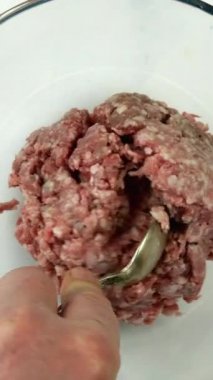 Şefin eli çiğ domuz ya da sığır etine tuz, biber, rendelenmiş soğan ve çiğ yumurta ekler. Pirzola ya da köfte için kıyma tarifi. Dikey video..