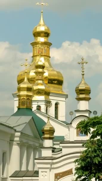 Monasterio cristiano ortodoxo. Domos dorados de catedrales e iglesias, monasterio de Kiev-Pechersk Lavra, cielo azul con nubes. Santuario cultural histórico. Kiev, Ucrania. Formato vertical. — Vídeo de stock