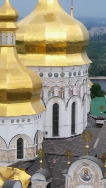 Ορθόδοξο χριστιανικό μοναστήρι. Χρυσοί τρούλοι καθεδρικών ναών και εκκλησιών, Μονή Kiev-Pechersk Lavra, γαλάζιος ουρανός με σύννεφα. Ιστορικό πολιτιστικό καταφύγιο. Κίεβο, Ουκρανία. Κάθετη μορφή. — Αρχείο Βίντεο