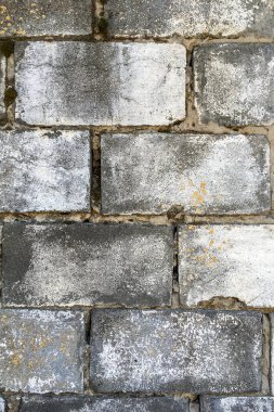 Eski moda antika gri tuğla duvar, zamanla yıpranır. Soyut tuğla arka plan ve doku. Dikey çekim. Yakın plan. Açık havada..