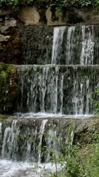 Cascada pequeña cascada con fuertes corrientes que se vierten en el hermoso parque. — Vídeos de Stock