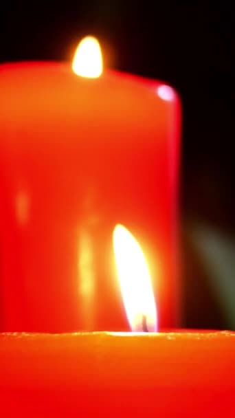 Different decorative candles burning in dark with wavering flames. Romantic evening or aromatherapy. Selective focus. Vertical video. Close-up. — Stock Video