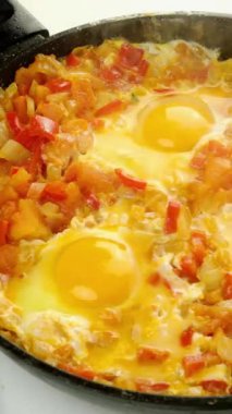 Şefin sebze soslu yumurtalı milk shuka 'sı kızartma tavasına hazırlanıyor. Yahudi ve Arap mutfağı. Shakshuka tarifi. Dikey video.