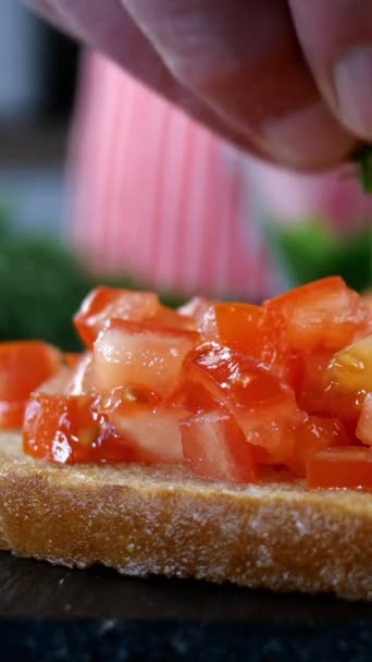 Koki taburan roti panggang dan potongan halus tomat merah dengan irisan dill untuk membuat sandwich atau bruschetta. Roti lapis vegetarian musim panas. Fokus selektif. Video Vertikal. Close-up. — Stok Video