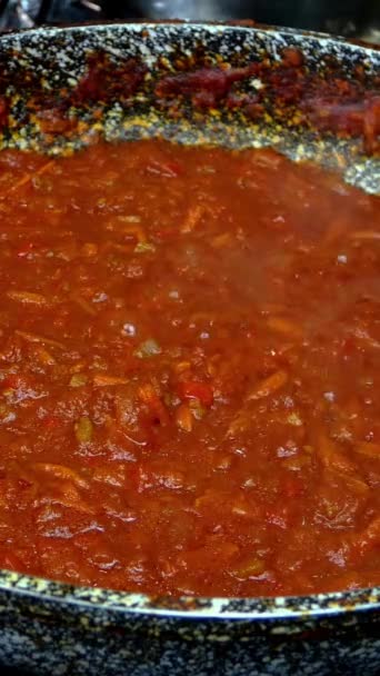 Espaguete posto em molho de tomate salgado com verduras, ferva na panela de ato de fritar no fogão a gás. Receita para fazer massa ou tagliatelle na cozinha da casa. Vídeo vertical. Close-up. — Vídeo de Stock