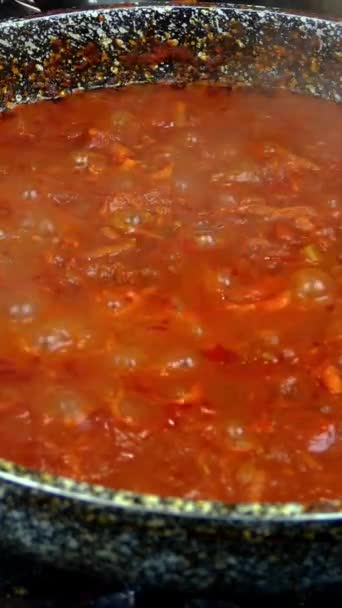 Molho de tomate salgado com legumes para massas ou pizza, cozinhe na frigideira no fogão a gás. Receita para fazer massa ou tagliatelle na cozinha da casa. Vídeo vertical. Close-up. — Vídeo de Stock