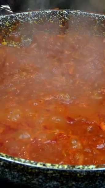 Saus tomat gurih dengan sayuran untuk pasta atau pizza, mendidih dalam penggorengan di atas kompor gas. Resep untuk membuat pasta atau tagliatelle di dapur rumah. Video Vertikal. Close-up. — Stok Video