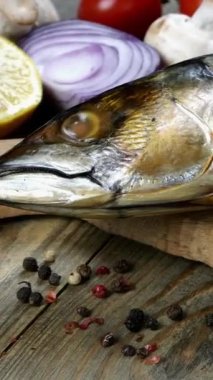 Kiraz domatesleri, soğan, mantar ve maydanozun yanındaki ahşap masada nefis füme balık uskumrusu. Sağlıklı Akdeniz yemek tarifi. Dikey video. Yakın plan..