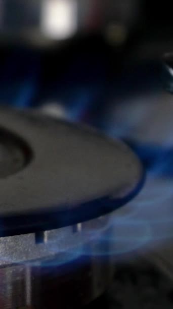 Процес горіння і появи блакитного полум'я газового метану або пропану на кухонній газовій плиті. Кухонний конфорка перемикається. Запалення природного газу. Вертикальне відео . — стокове відео