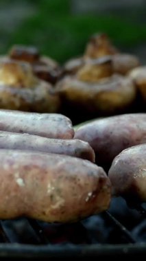 Izgarada ya da ızgarada pişirilmiş yağlı bavyera sosisi. Mantarlı ve domatesli. Dikey video. Yakın plan..