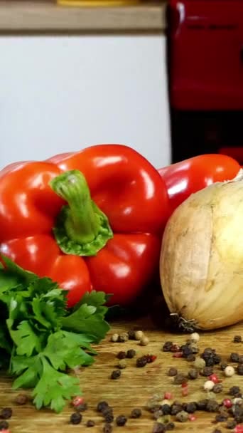 Variedad de verduras frescas y crudas se encuentran en un montón en la mesa de la cocina. Ingredientes para ensalada de verduras u otros platos de verduras. Concepto de comida vegetariana o vegana saludable. Vídeo vertical. — Vídeo de stock