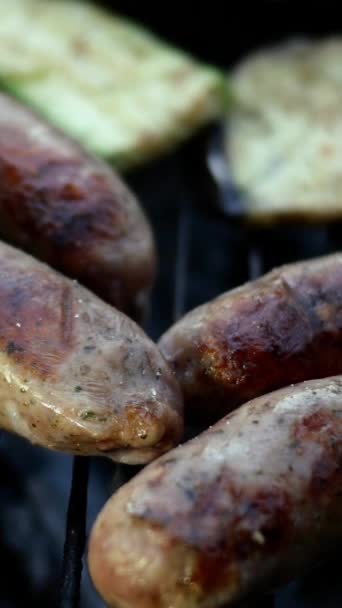 Friggere le salsicce bavaresi grasse cotte alla griglia o alla griglia. Con le verdure. Video verticale. Primo piano. — Video Stock