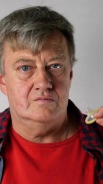 Kıdemli adam elinde prezervatif tutan, Ok gösterir ve gülümsüyor, kameraya bakarak. Yaşlı yaşta aktif cinsel yaşam kavramı.