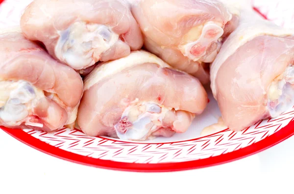 Pierna de pollo en un plato blanco con un borde rojo . — Foto de Stock