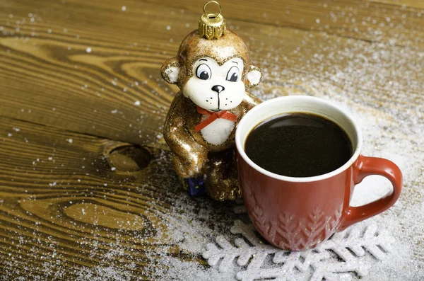 Noel Maymunu yakınındaki bir kırmızı kahve fincanı.