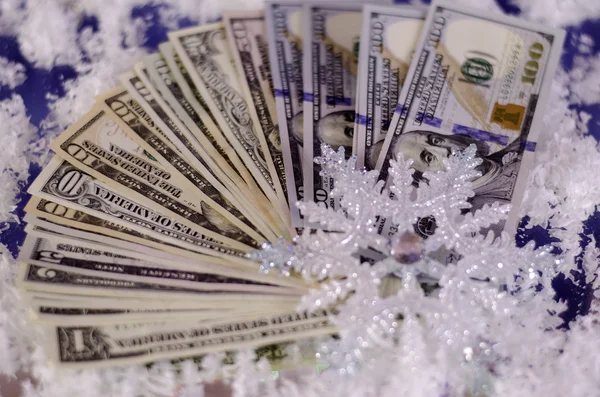 Snowflake and dollar bills of different denominations. — Stock Photo, Image