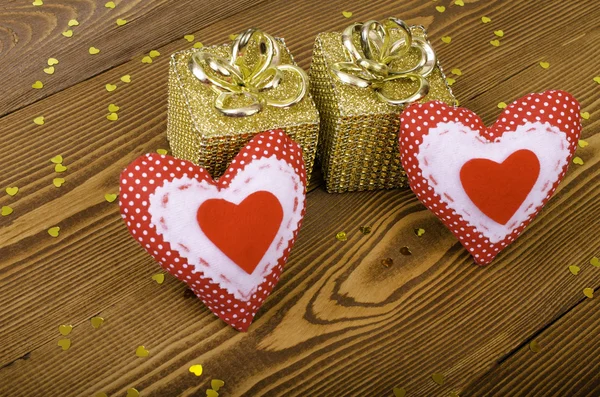 Czerwone serca i dwa złota prezent. — Zdjęcie stockowe