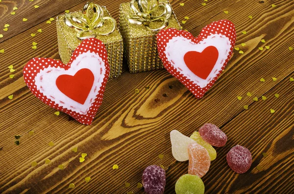 Red hearts, two golden gift and fruit candy. — Stock Photo, Image