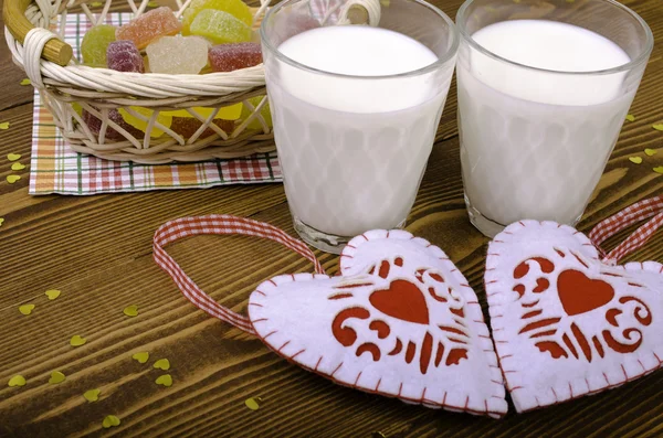 Dwa serca, marmoladę w wiklinowym koszu i dwie szklanki mleka — Zdjęcie stockowe