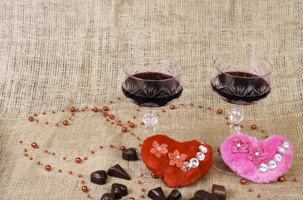 Kieliszków wina, dwa serca i cukierki czekoladowe. — Zdjęcie stockowe
