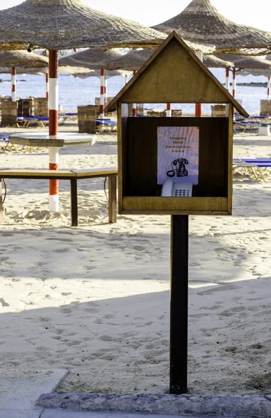 Noodtelefoon in een houten stand op het strand. — Stockfoto