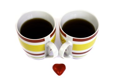 İki bardak çay ve beyaz bir arka plan üzerinde kalp.