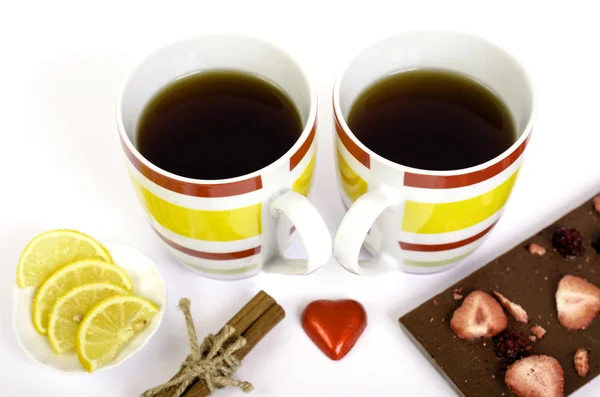 Two cups of tea, chocolate, lemon and cinnamon on white backgrou — Stock Photo, Image