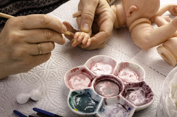 Hand painted reborn dolls. Painting brush fingers. — Stock Photo, Image