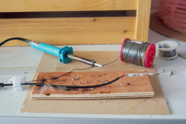 Soldering tools with electrical items on the table.