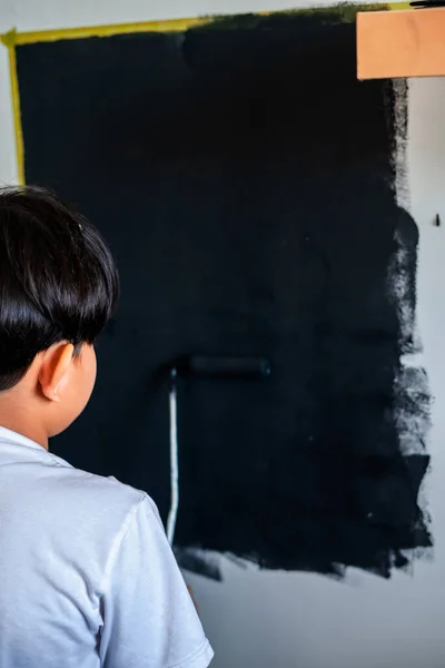 Criança Pintando Uma Parede Cor Preta Vista Por Trás — Fotografia de Stock